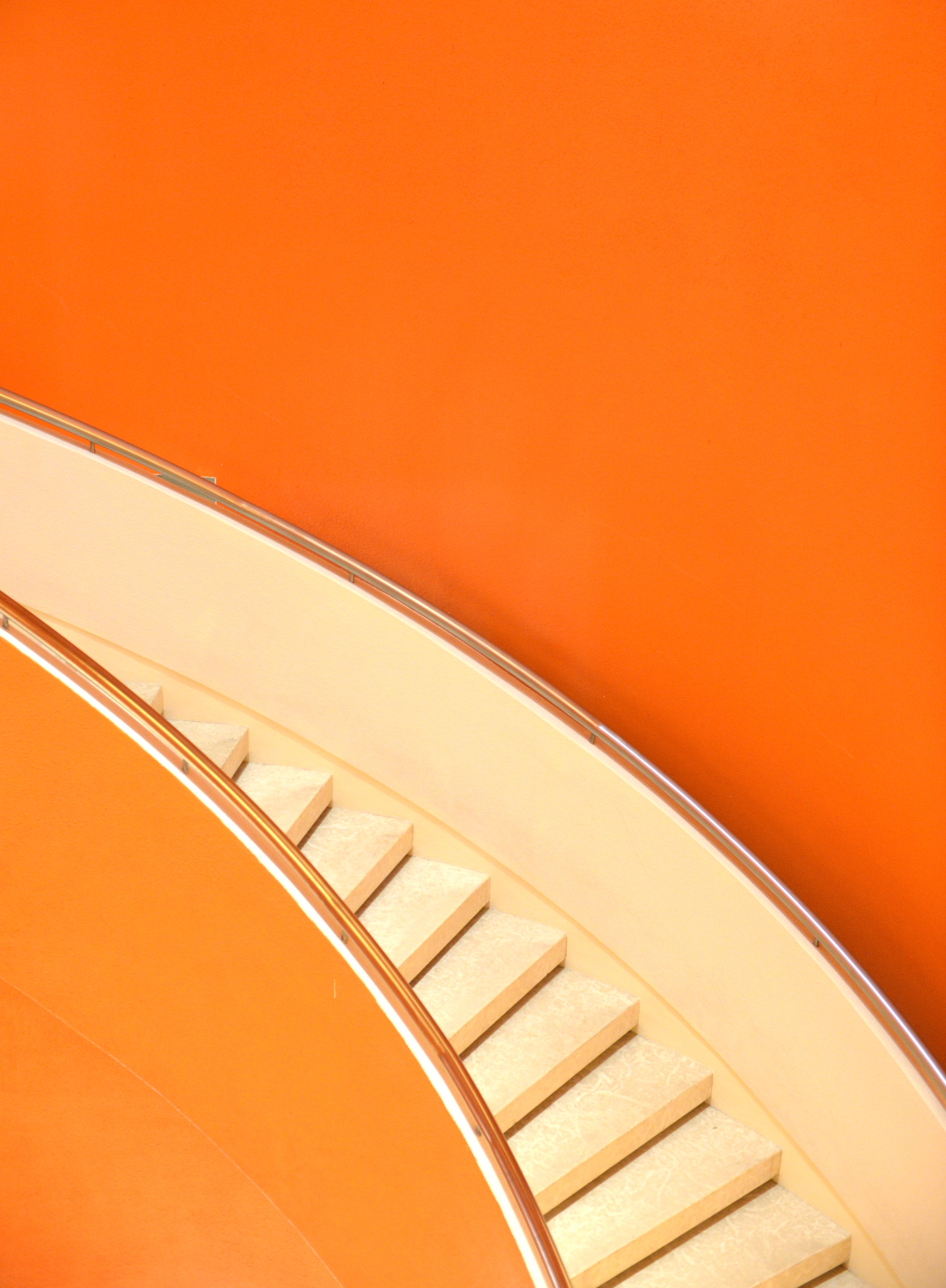 Artsy staircase with neon light and orange background.